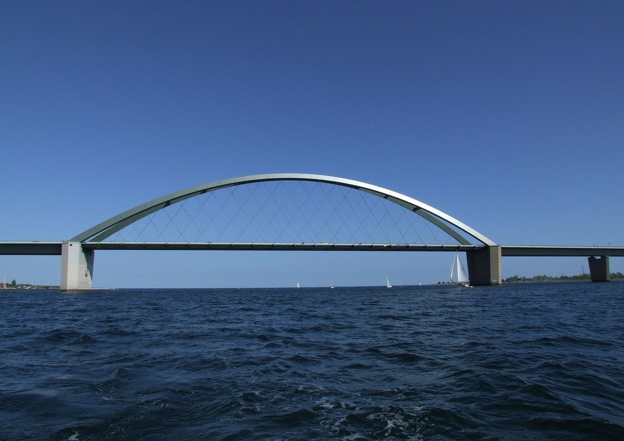 Fehmarnbeltquerung: Brücke über dem Wasser mit metallenem Stabilisationsbogen