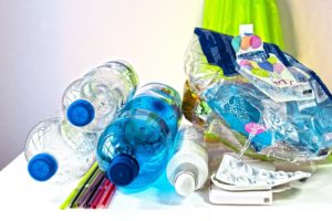 Alltagsgegenstände aus Plastik, wie Wasserflaschen und Plastikstrohhalme sind übereinander gestapelt