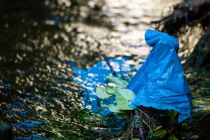blaue Mülltüte im Matsch oder am Flussufer