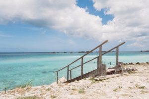 Eine Leiter führt vom Strand runter zum türkisenen Wasser in der Karibik