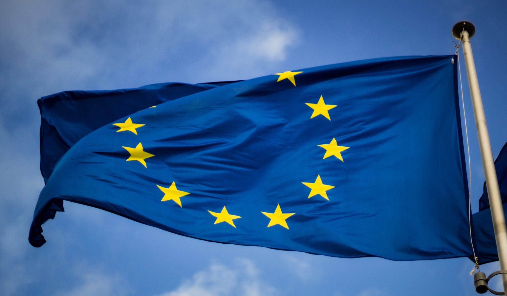 Vor blauem Himmel weht die Flagge der EU