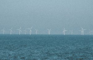 Viele Windräder stehen in der Ferne im Meer, das Wetter sieht stürmisch aus