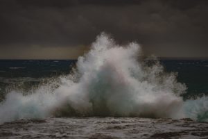 Eine große Welle bricht über der Meer