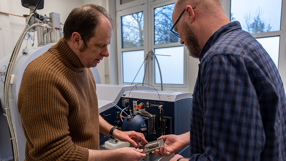 Ein La­ser, ge­kop­pelt an ein Mas­sen­spek­tro­me­ter, hilft Dr. Lars Wör­mer (rechts) und Prof. Kai-Uwe Hin­richs da­bei, die Li­pid-Bio­mar­ker in je­der Mil­li­me­ter brei­ten Schicht zu ent­schlüs­seln.
