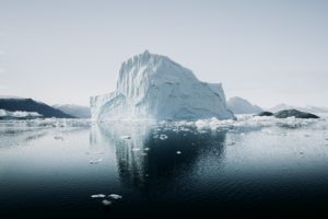 Ein großer Eisberg erstreckt sich vor Grönland und spiegelt sich im Wasser