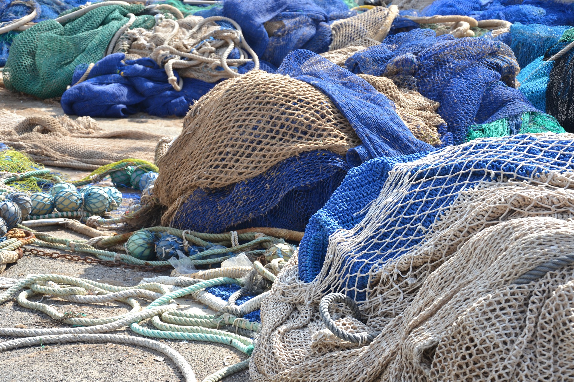 Mehrere blaue und weiße Fischereinetze liegen übereinander